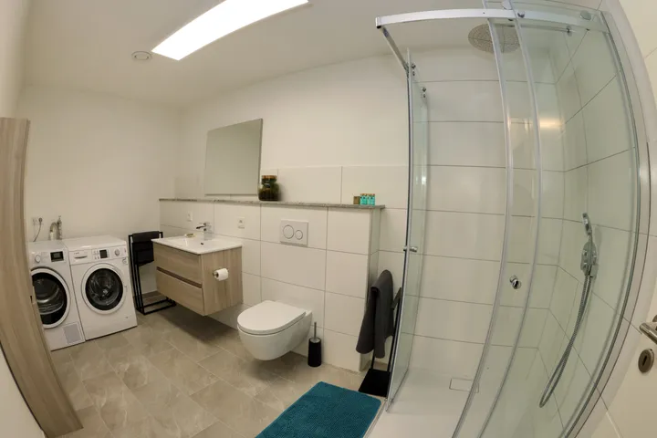 Bathroom with washing machine, dryer and rain shower