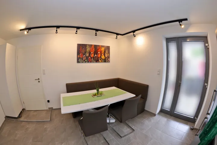 Dining area with a corner bench, table and a wall painting