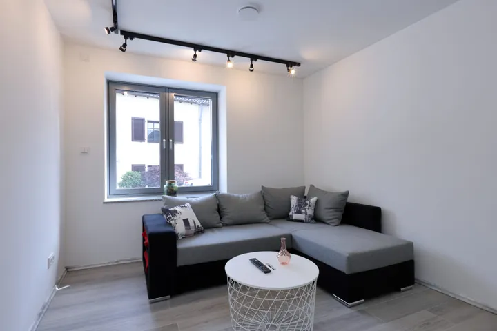 Cozy living room with corner sofa, coffee table and smart TV in the Wallerfangen holiday apartment