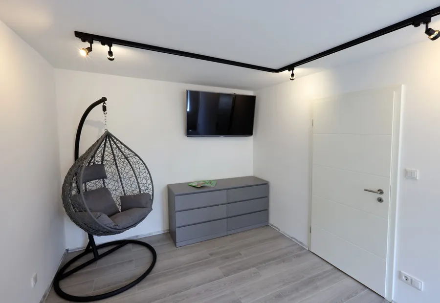 Reading corner in the living room with a hanging chair and sideboard