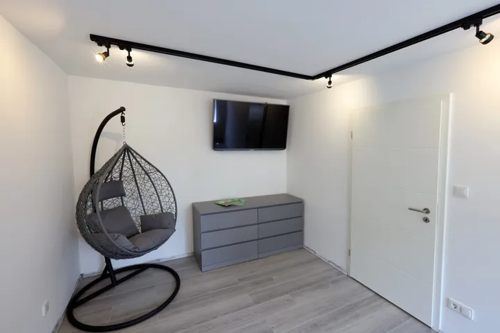 Reading corner in the living room with a hanging chair and sideboard
